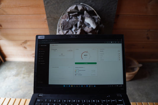 Sauna dashboard on laptop with Huum Drop 9kW heater in the background